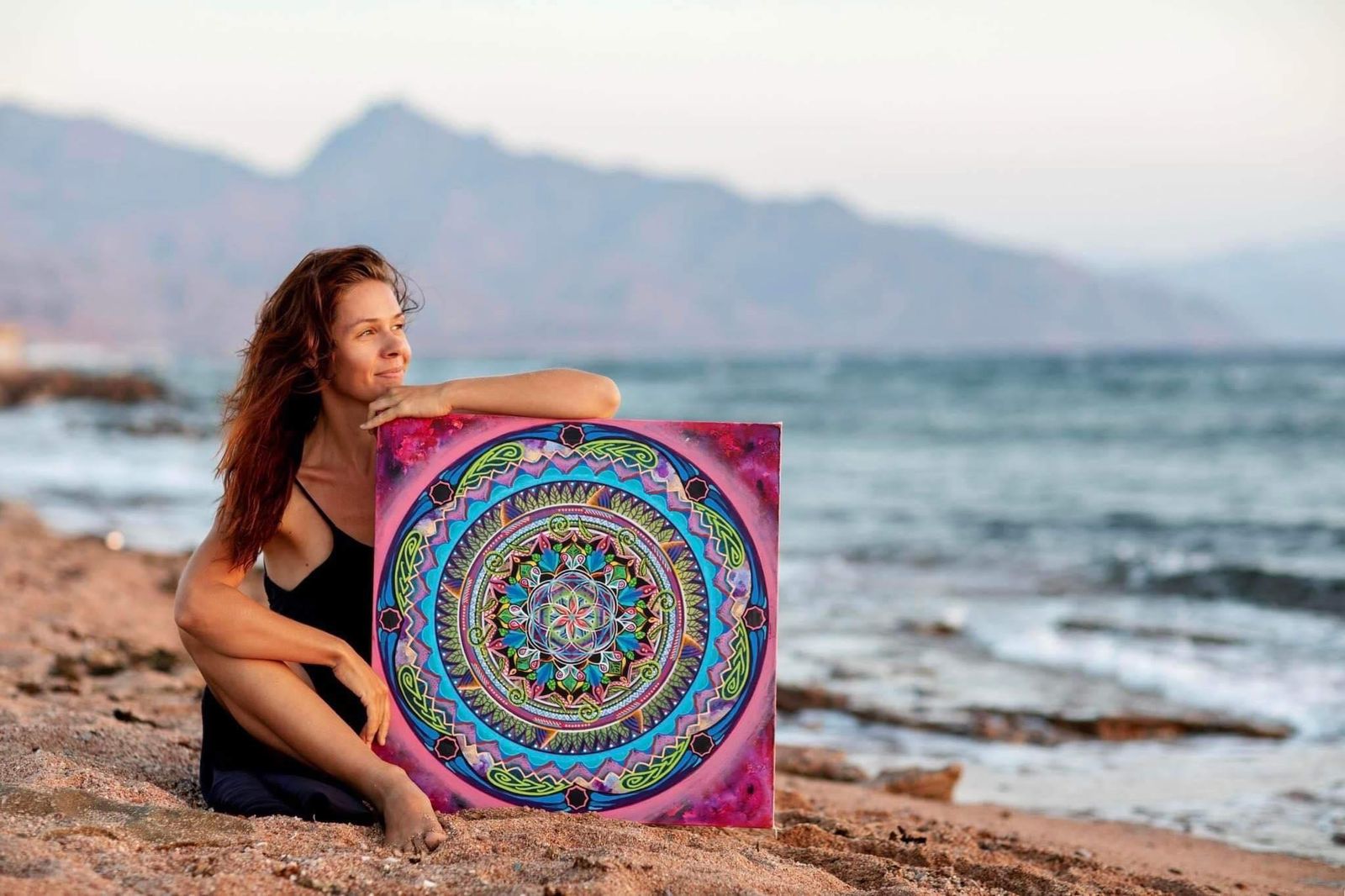 Ela with mandala on beach shore